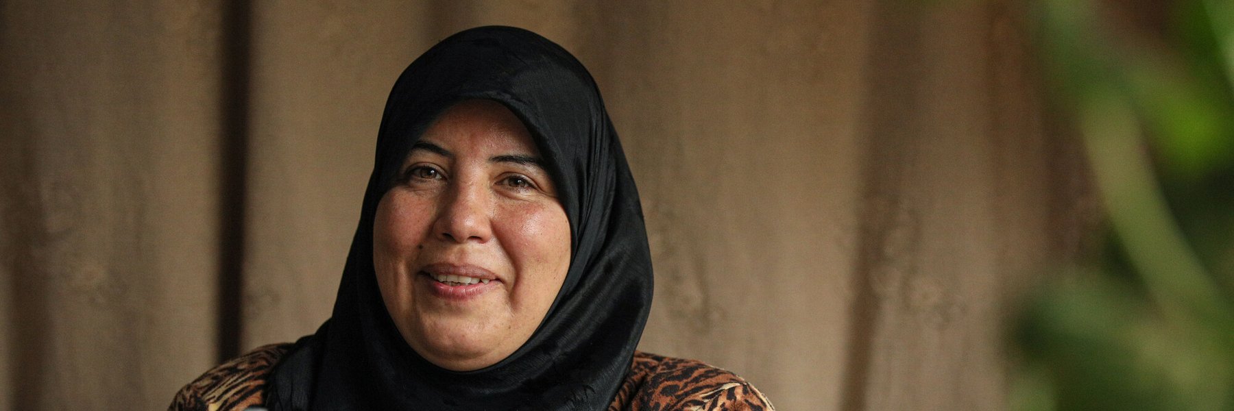 Amal, 48, a mother from Aleppo, with the sewing machine she received from Oxfam to improve her income.