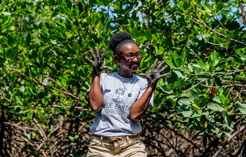 Joyce Koech poses for a photo with muddy hands in Mombasa County, Kenya.