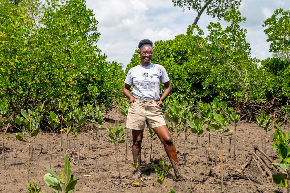 Climate activist, Joyce Koech, stands among recently planted mangroves as part of her pioneering restoration project in Mombasa, Kenya.