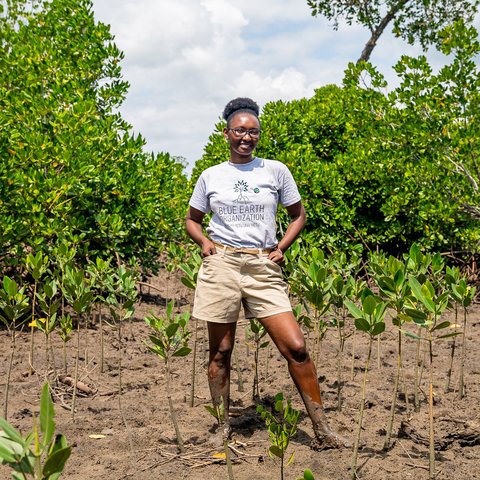 Climate activist, Joyce Koech, stands among recently planted mangroves as part of her pioneering restoration project in Mombasa, Kenya.