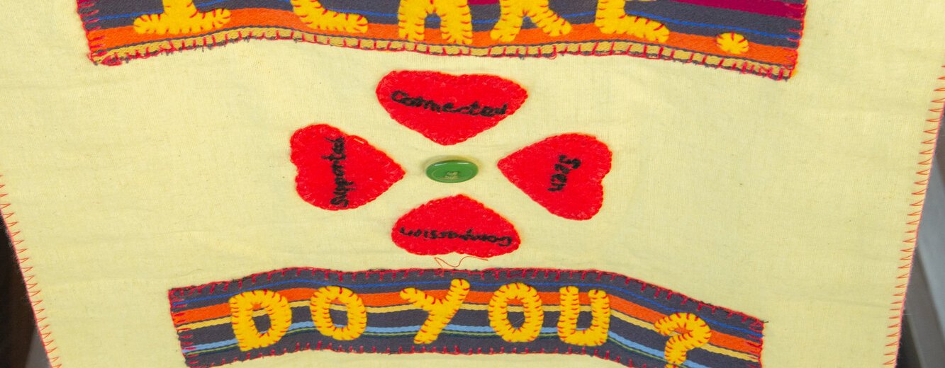 A piece of artwork from We Care / Oxfam Cymru’s Caring Craftivist campaign exhibition event. Text reads 'I care. Do you?'