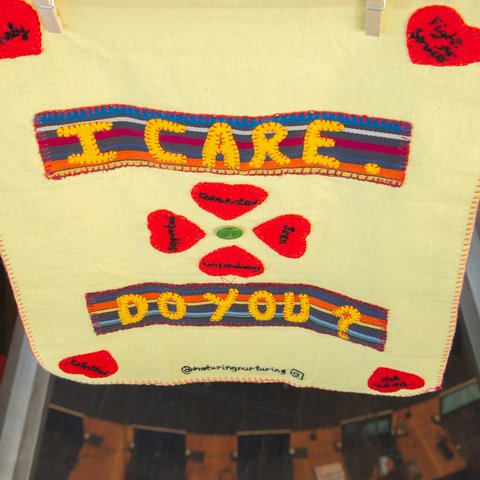 A piece of artwork from We Care / Oxfam Cymru’s Caring Craftivist campaign exhibition event. Text reads 'I care. Do you?'