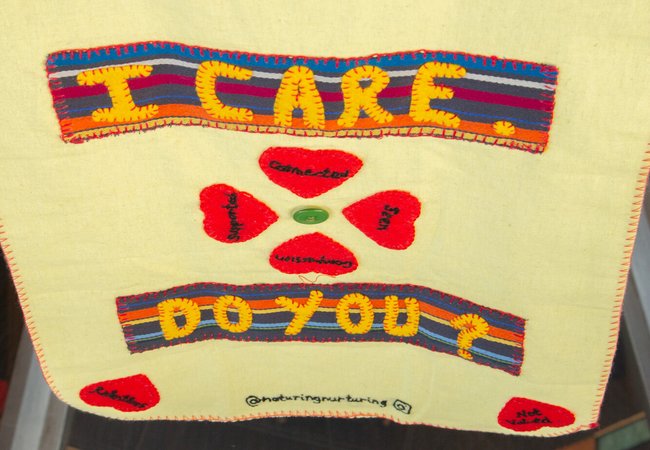 A piece of artwork from We Care / Oxfam Cymru’s Caring Craftivist campaign exhibition event. Text reads 'I care. Do you?'