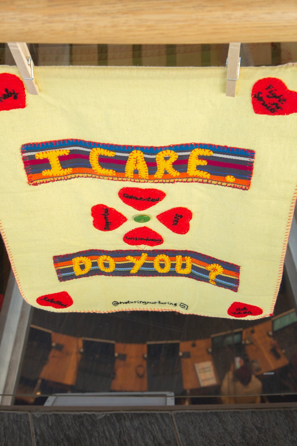 A piece of artwork from We Care / Oxfam Cymru’s Caring Craftivist campaign exhibition event. Text reads 'I care. Do you?'