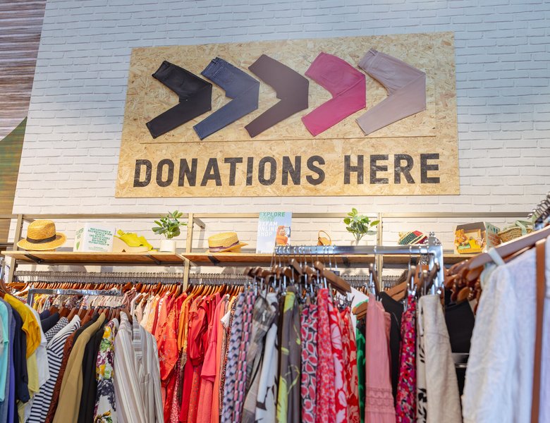 'Donations Here' sign above clothes on rail at Manchester Superstore.