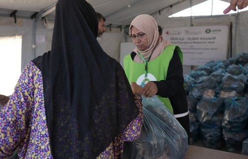 A woman is receiving a vegetable basket distributed by Oxfam and partners in Deir Al Balah in the middle of Gaza.