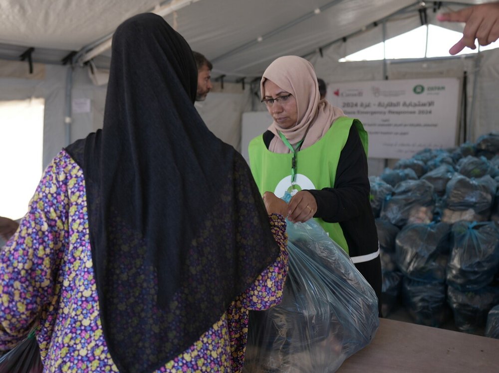 A woman is receiving a vegetable basket distributed by Oxfam and partners in Deir Al Balah in the middle of Gaza.
