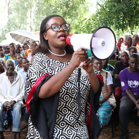 Lingalireni Mihowa stands with a megaphone and addresses a crowd