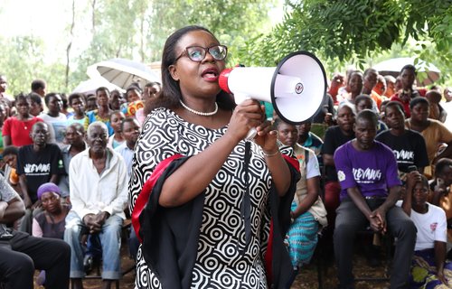 Lingalireni Mihowa stands with a megaphone and addresses a crowd