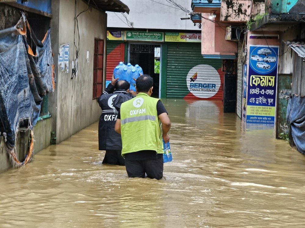 Two men wading through flood water in Bangladesh