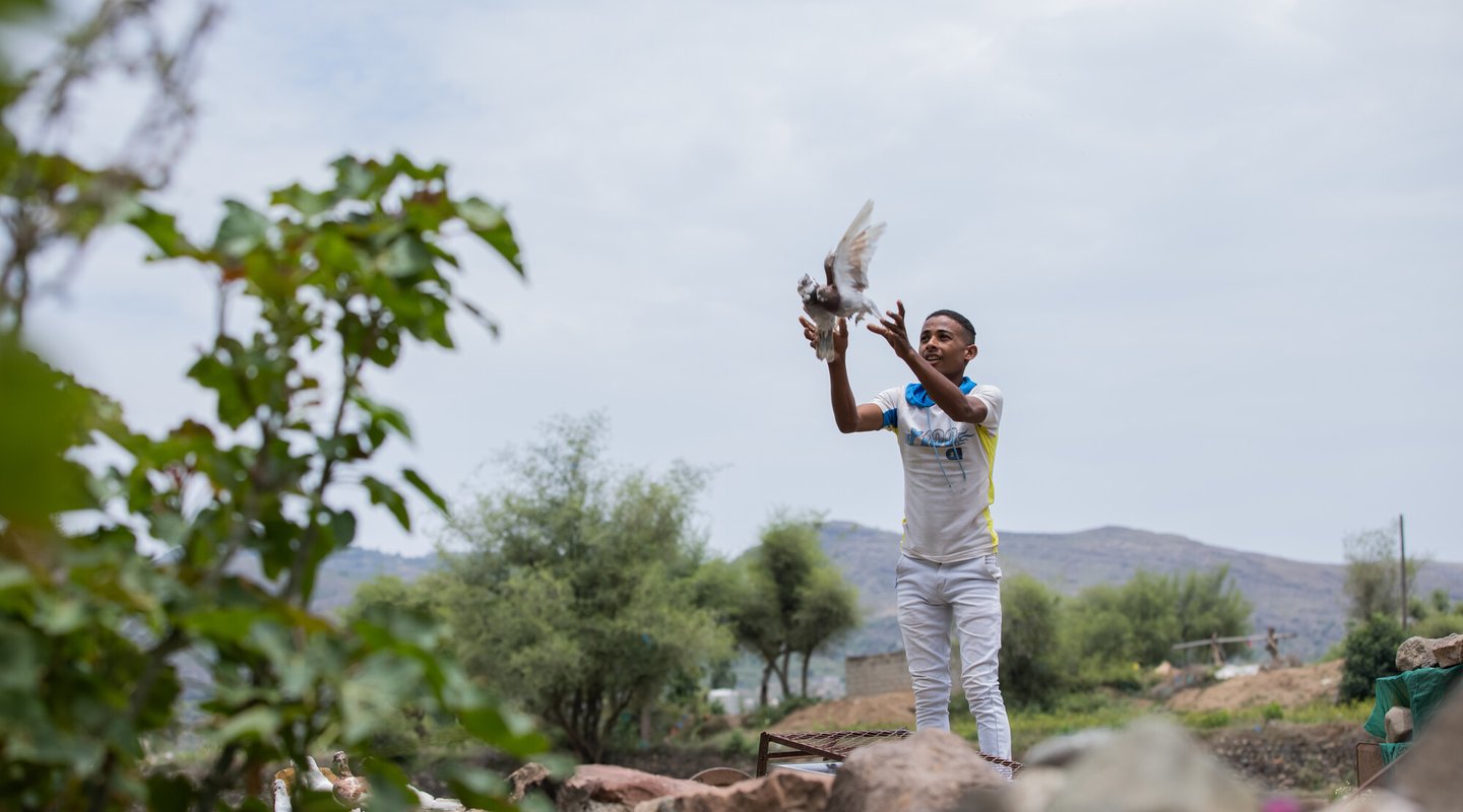 22-year-old Munadhel releases one of the pigeons his family breeds at their home in rural Yemen.