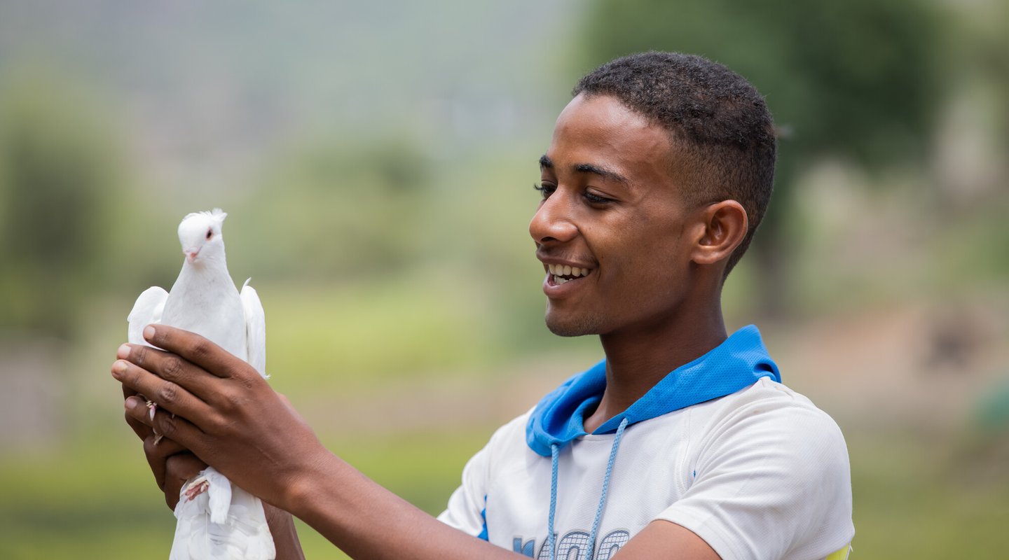 Munadhel holds one of the pigeons his family breeds.