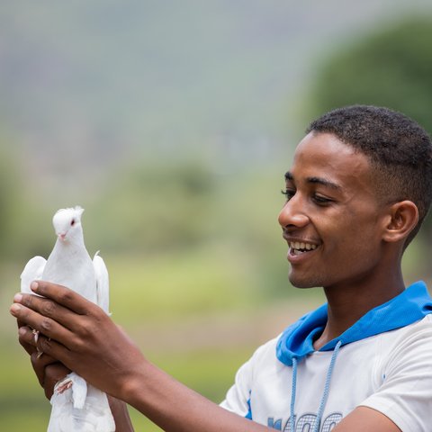 Munadhel holds one of the pigeons his family breeds.