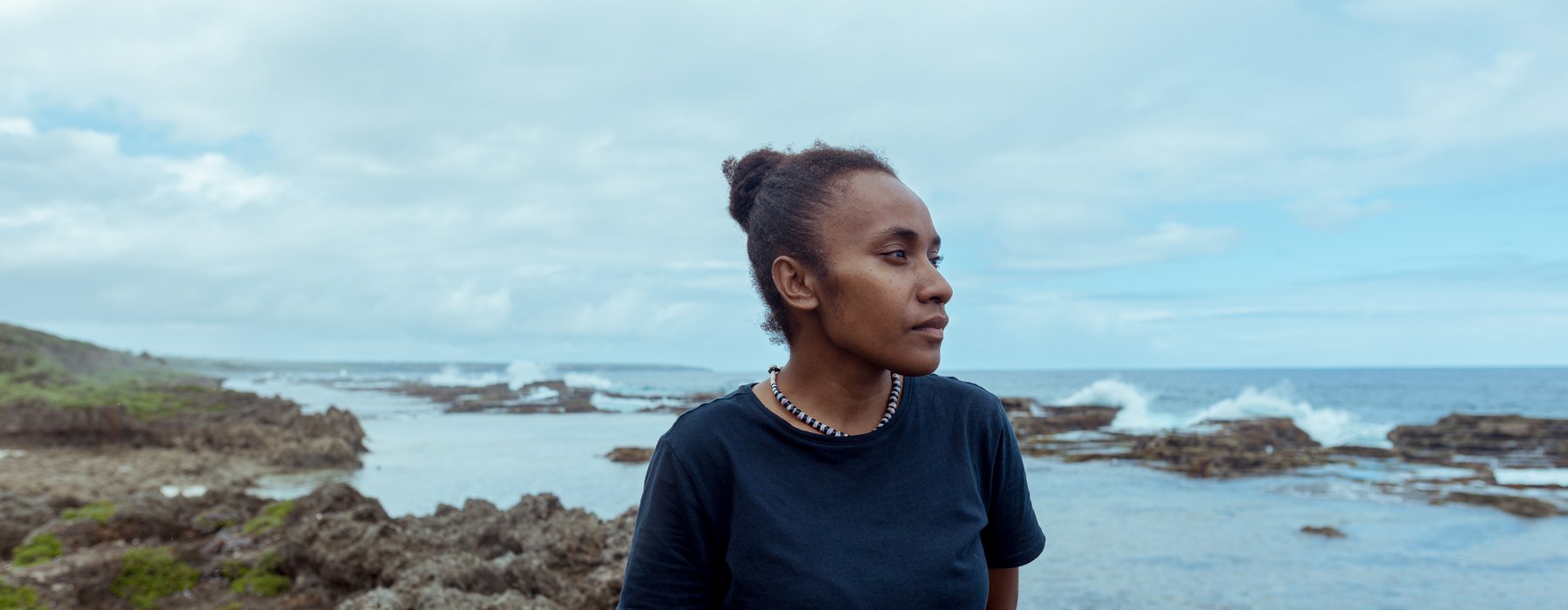 Cynthia standing on a rock looking out to sea