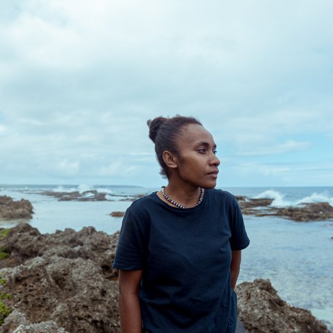 Cynthia standing on a rock looking out to sea