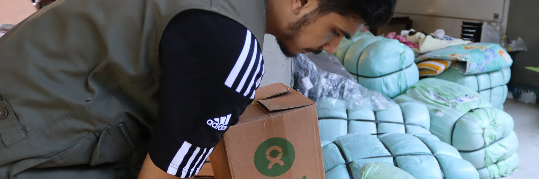 A man holds a box of Oxfam aid.