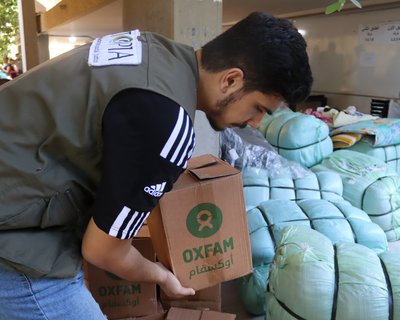 A man holds a box of Oxfam aid.