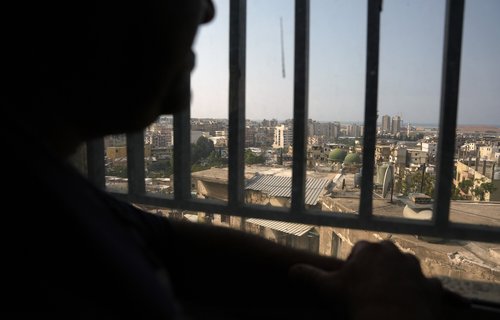 Habib, a displaced man, at his shelter in North Lebanon, looks through the shelter's window