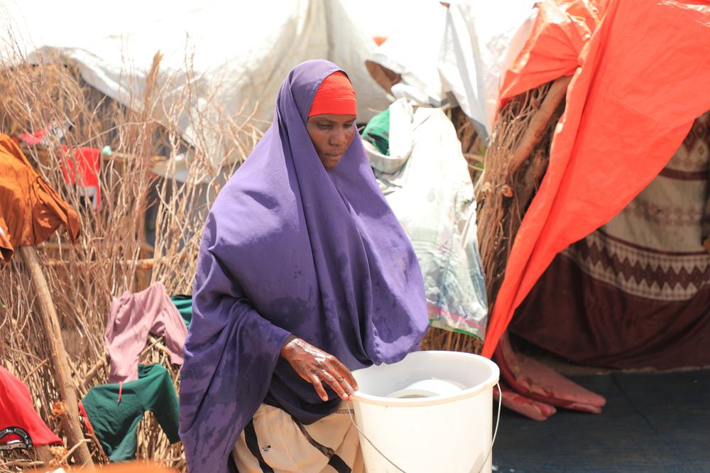 Barwaaqo Mohamud Hare carrying a bucket of water at her home in Beledweyne.