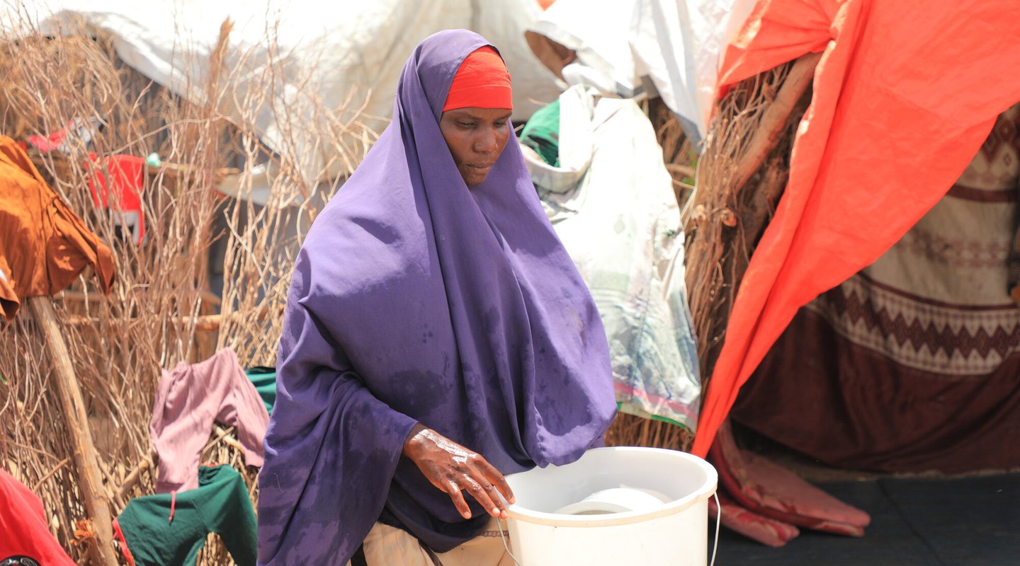 Barwaaqo Mohamud Hare carrying a bucket of water at her home in Beledweyne.