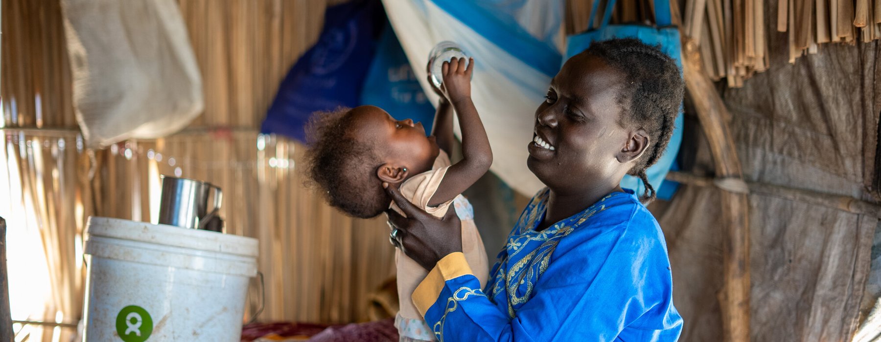 33-year-old Ayul Ajak, a visually impaired mother of six plays with her child at her home in her makeshift home in Renk, South Sudan.