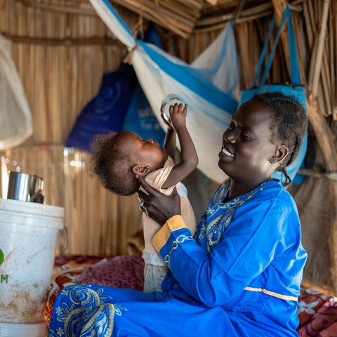 33-year-old Ayul Ajak, a visually impaired mother of six plays with her child at her home in her makeshift home in Renk, South Sudan.