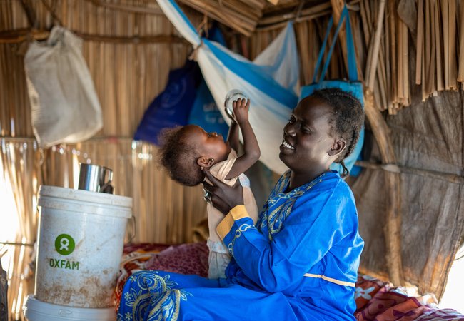 33-year-old Ayul Ajak, a visually impaired mother of six plays with her child at her home in her makeshift home in Renk, South Sudan.