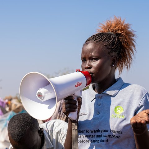 Oxfam health promoter Jun Ajuk speaks to Sudanese refugees and returnees on the importance of maintaining hygiene to avoid the spread of disease.
