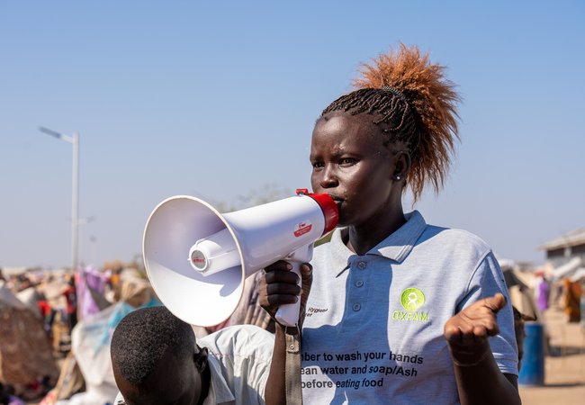 Oxfam health promoter Jun Ajuk speaks to Sudanese refugees and returnees on the importance of maintaining hygiene to avoid the spread of disease.