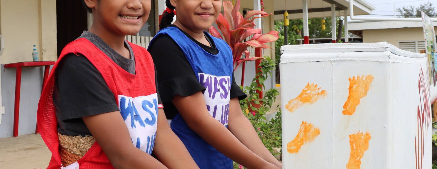 Nine year old Christopher and Nanise smile as they wash their hands at Pangai Primary School on remote Ha'apai island in Tonga.