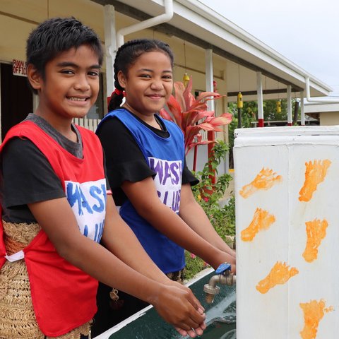 Nine year old Christopher and Nanise smile as they wash their hands at Pangai Primary School on remote Ha'apai island in Tonga.