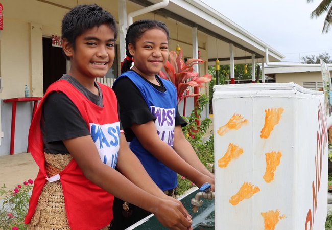 Nine year old Christopher and Nanise smile as they wash their hands at Pangai Primary School on remote Ha'apai island in Tonga.