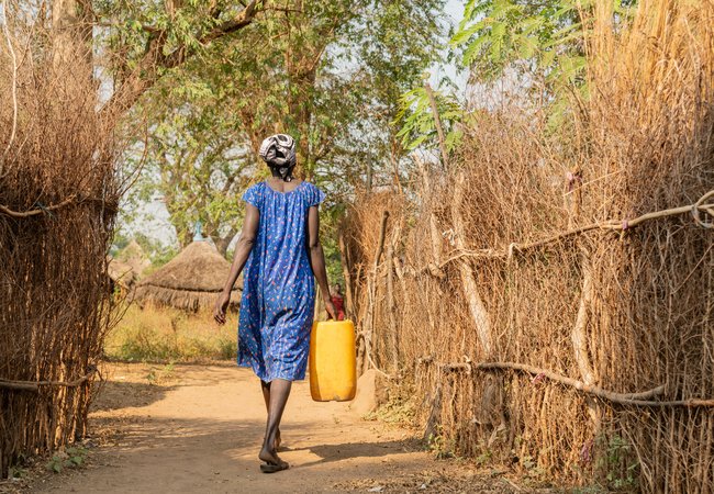 Myhtuk Hukuch, 34, walks to fetch water from a water point in Kule South Sudanese refugee camp, Gambella.