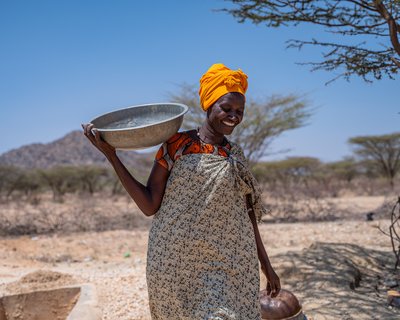 Alice Lourien carries crashes of rocks on her shoulders where she works at a mining center in Turkana, Marsabit county.