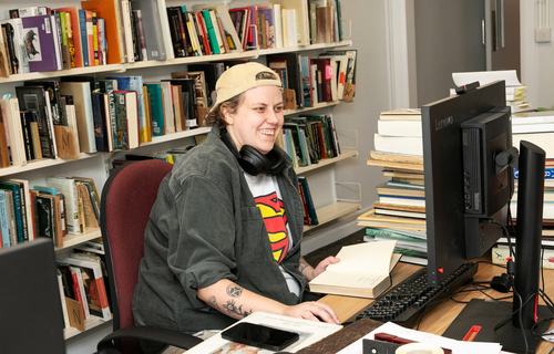 Volunteer Millie works at a computer in Oxfam's shop in Hove.