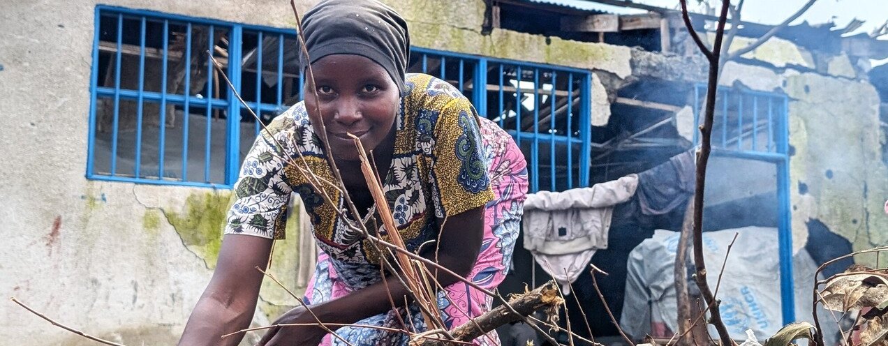 Muhawe Myriam Charmante is smiling and looking at the camera while collecting firewood at the collective gathering site in Sake, DRC