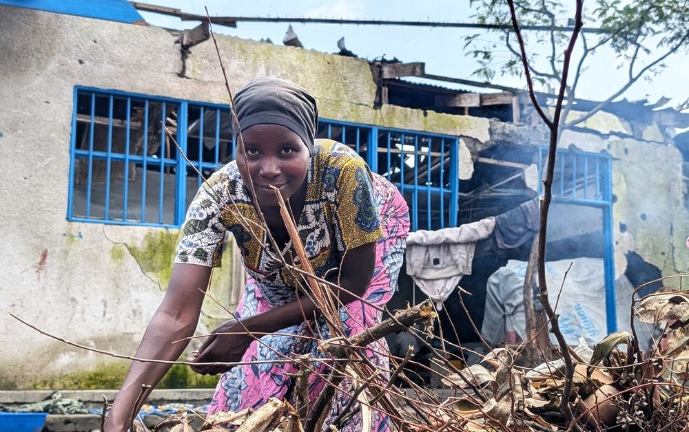 Muhawe Myriam Charmante is smiling and looking at the camera while collecting firewood at the collective gathering site in Sake, DRC