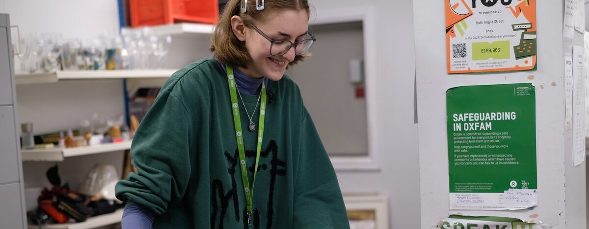 A woman smiling and looking into a box of donations
