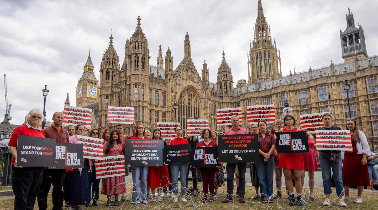 Campaigners hold placards during Red Line for Gaza action in Westminster.