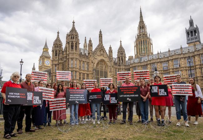 Campaigners hold placards during Red Line for Gaza action in Westminster.