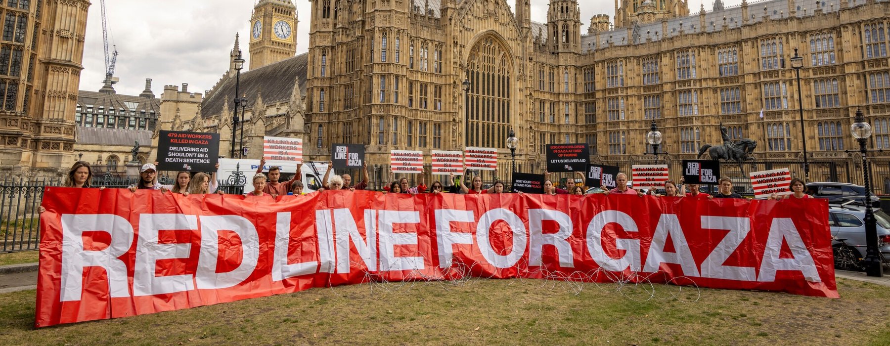 Protest outside of Westminster - a line of people holding a banner that says Red Line for Gaza