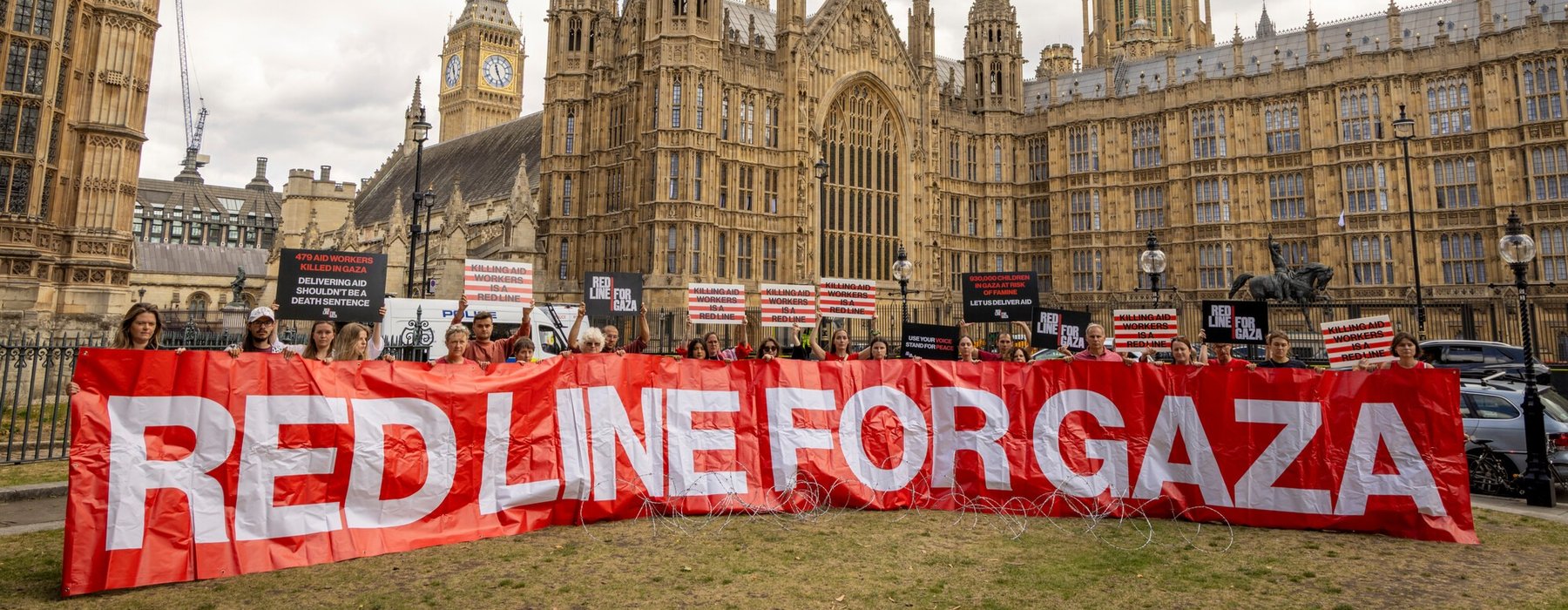 Protest outside of Westminster - a line of people holding a banner that says Red Line for Gaza