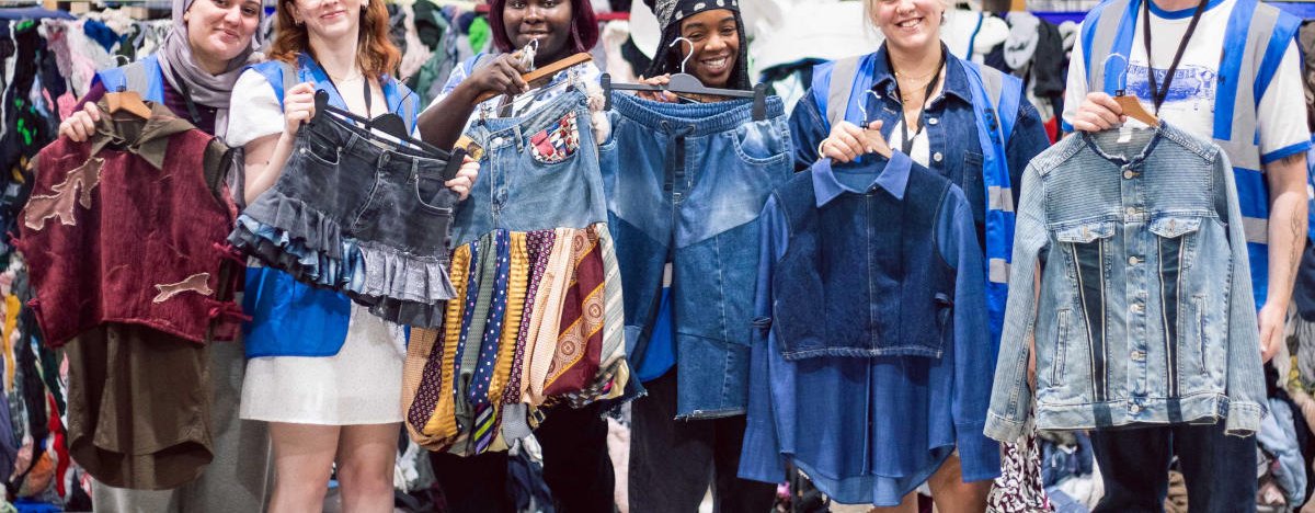 Upcycling students from Leeds Beckett university pose with their upcycled clothes at Oxfam's Batley warehouse.
