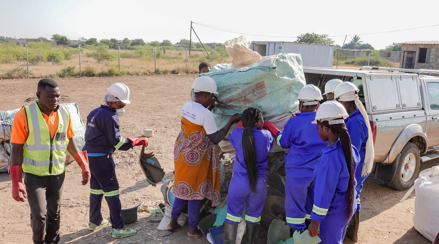 Members of the Solid Waste Management Centre unload recyclables from a truck.