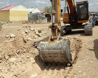 An excavator at work, digging trenches for pipelines