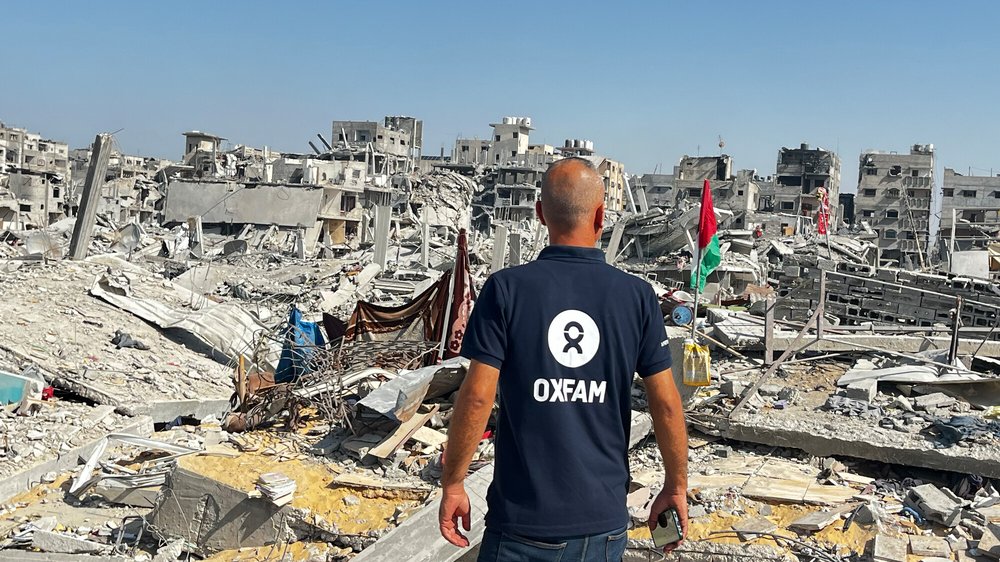 Oxfam Staff Ihab stands looking at the ruins of destroyed buildings in Gaza City after the ceasefire was declared.