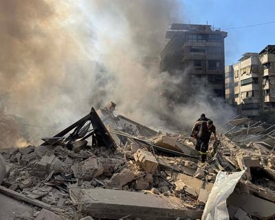 Rescue workers search through the rubble after Israel's overnight bombing of Beirut's southern suburbs.