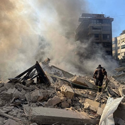Rescue workers search through the rubble after Israel's overnight bombing of Beirut's southern suburbs.