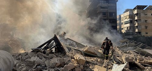 Rescue workers search through the rubble after Israel's overnight bombing of Beirut's southern suburbs.