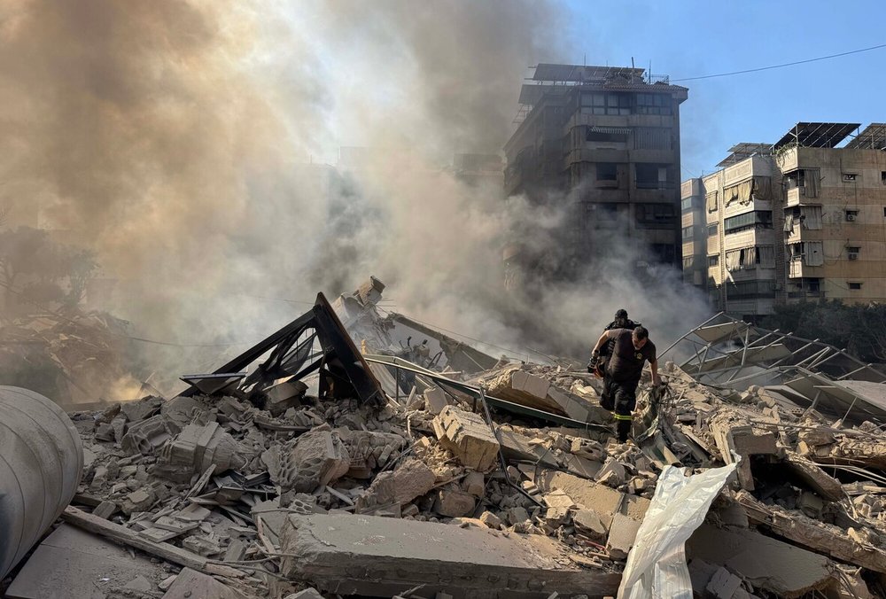Rescue workers search through the rubble after Israel's overnight bombing of Beirut's southern suburbs.